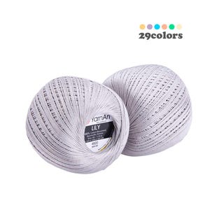 Könnte beinhalten: Zwei Knäuel graues Garn, beschriftet mit "YarnAn Lily 100% Baumwolle mercerisiert 50 g - 1,76 oz 225 m - 245 yds 4920 888130"