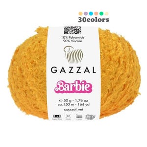 Op de afbeelding: Een bol gele, pluche garen met het label "GAZZAL Barbie" met de tekst "10% Polyamide 90% Viscose" en "50 g - 1,76 oz ca. 150 m - 164 yd gazzal.net".