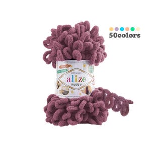 May include: A roll of Alize Puffy yarn in a deep mauve color. The yarn is soft and fluffy, and the label says "Soft & Delicate" and "Alize Puffy".