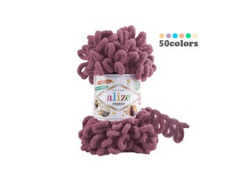 May include: A roll of Alize Puffy yarn in a deep mauve color. The yarn is soft and fluffy, and the label says "Soft & Delicate" and "Alize Puffy".