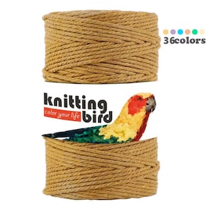 Può includere: Un rotolo di corda spessa di colore marrone dorato, con il testo "Knitting Bird, color your life" su un'etichetta davanti ad esso. L'etichetta presenta anche un'illustrazione di pappagallo colorato. Il testo "36 colori" è visualizzato sopra il rotolo.