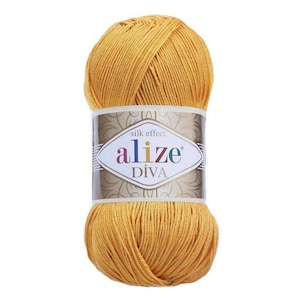 Peut inclure: Une pelote de fil jaune avec une étiquette qui indique "silk effect alize DIVA".