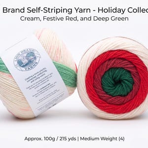 May include: Two balls of Lion Brand self-striping yarn from the Holiday Collection. One ball is partially unwound, displaying cream, festive red, and deep green stripes. The other ball is fully wound, showing concentric circles of the same colors. The label reads "Lion Brand Yarns".