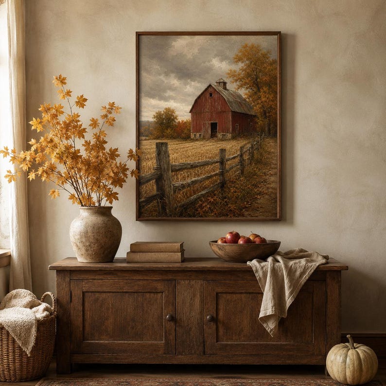 Red barn in an autumn field art print framed above a dark sideboard — rustic farmhouse fall decor from a vintage Halloween and fall print bundle.