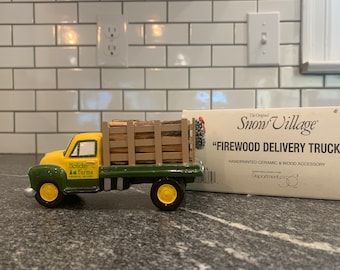 May include: A hand-painted ceramic and wood "Firewood Delivery Truck" figurine. The truck is yellow and green with a load of wood in the back. The text "Holiday Farms" is on the side. The wheels are yellow.