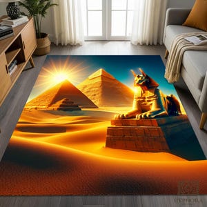 Op de afbeelding: Een rechthoekig vloerkleed met een Egyptisch woestijnlandschap met piramides en een sfinx. Het ontwerp heeft een levendig kleurenpalet van geel, oranje en blauw, met een heldere zon. Het vloerkleed is geschikt voor binnengebruik.
