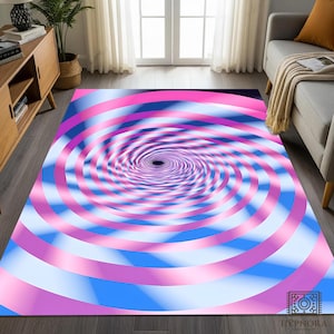 May include: A rectangular rug with a spiral design in shades of pink, blue, and white. The rug features a central vortex and the brand name "HYPNORA" in the bottom right corner. The design creates an optical illusion.