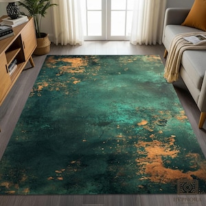 May include: A rectangular area rug with a distressed, abstract design. The rug features a dark teal and emerald green base color with accents of gold and bronze. The rug has a textured appearance, with a faded, mottled pattern.