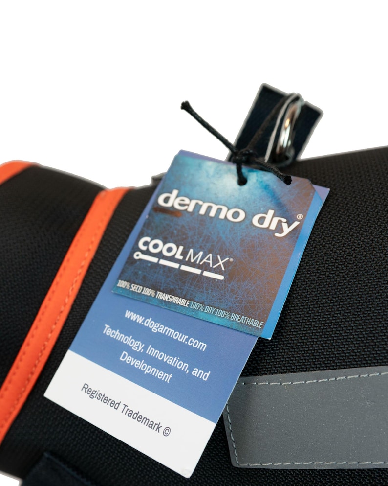 May include: A black dog harness with a bright orange trim and a white tag that says "dermo dry COOLMAX 100% SECO 100% TRANSPIRABLE 100% DRY 100% BREATHABLE www.dogarmour.com Technology, Innovation, and Development Registered Trademark &copy;"