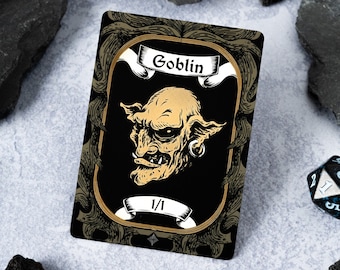 Könnte beinhalten: Eine schwarze und goldene Karte mit einer Illustration eines Kobolds. Die Karte trägt den Text "Goblin" und "1/1".