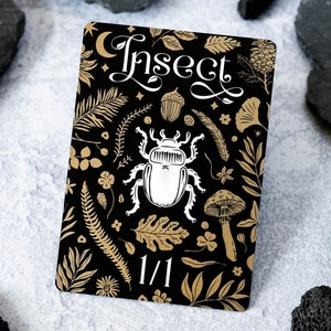 May include: A black card with gold floral and insect illustrations. The card has the word "Insect" in white cursive lettering and the number "1/1" in white lettering at the bottom.