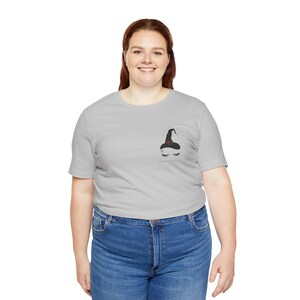 May include: A gray t-shirt with a black witch hat and eyelashes graphic. The text "I'm brewing trouble" is printed below the graphic.