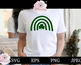 May include: A white t-shirt with a green shamrock rainbow design. The design features a rainbow with a shamrock in the center.