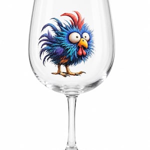 May include: A clear glass wine glass featuring a colorful illustration of a fluffy, wide-eyed chicken with blue and purple feathers, a bright red comb, and a yellow beak. The chicken has a startled expression and stands on textured yellow feet.