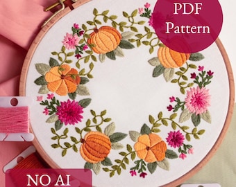 May include: A circular embroidery hoop featuring a floral design with orange pumpkins, pink flowers, and green leaves. The text "PDF Pattern" is in a burgundy circle. The text "NO AI 100% human made" is at the bottom. Embroidery floss is visible.