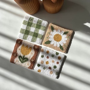 Coaster made with punch needle technique, with a floral pattern on it, dominated by green and brown tones