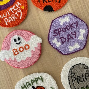 May include: Six colorful round and hexagonal felt ornaments with Halloween themes. The ornaments feature phrases like "Witch Party", "Boo", "Happy Halloween", "Spooky Day", and "Or Treat".