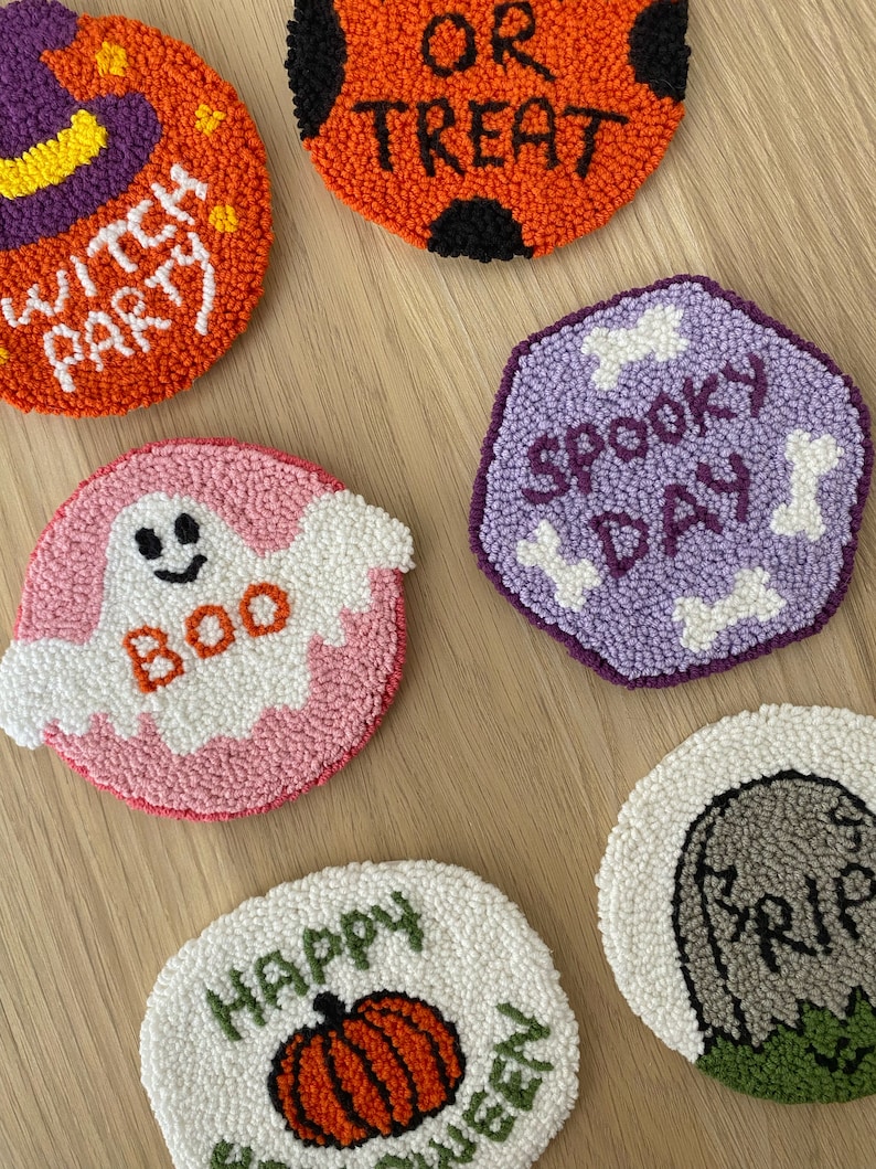 May include: Six colorful round and hexagonal felt ornaments with Halloween themes. The ornaments feature phrases like "Witch Party", "Boo", "Happy Halloween", "Spooky Day", and "Or Treat".