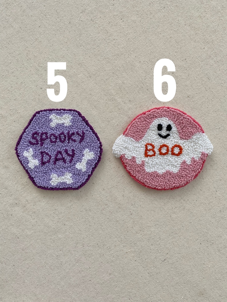 May include: Two handmade felt ornaments, one purple with the text "Spooky Day" and the other pink with a white ghost and the text "Boo".