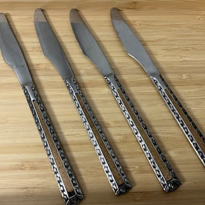 Puede incluir: Cuatro cuchillos de cena de plata con incrustaciones de corcho en los mangos.