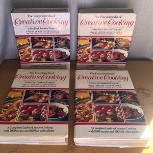 May include: Four copies of "The Encyclopedia of Creative Cooking" cookbook are shown. The books have white covers with red and gold lettering. The cover features a collage of full-colour food photos. The text reads "A Complete Guide to Creative Cooking with 2000 recipes and 800 full-colour photos."