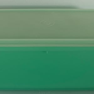 May include: A light green plastic storage container with a lid. The container is rectangular and has a smooth surface.