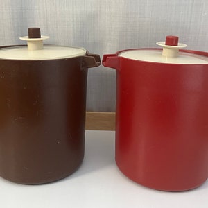 May include: Two plastic jugs with lids. One is brown and the other is red.
