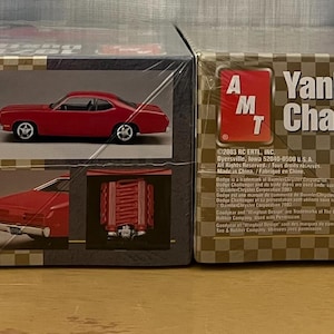 Op de afbeelding: Twee modelbouwsets voor auto's, een is een 1971 Plymouth Duster Street Machine en de andere is een Yankee Challenge. Beide sets zijn van AMT.