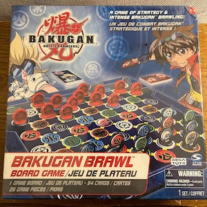 Peut inclure: Un jeu de société Bakugan Battle Brawlers avec un plateau de jeu rouge, blanc et bleu, 54 cartes et 26 pions. La boîte présente une illustration de deux personnages de la série Bakugan.