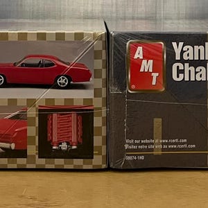 Op de afbeelding: Twee modelbouwsets voor auto's, een is een 1971 Plymouth Duster Street Machine en de andere is een Yankee Challenge. Beide sets zijn van AMT.