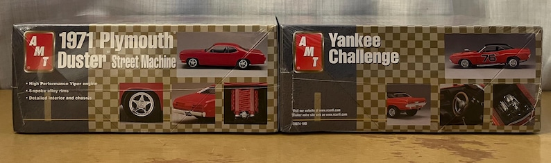 Op de afbeelding: Twee modelbouwsets voor auto's, een is een 1971 Plymouth Duster Street Machine en de andere is een Yankee Challenge. Beide sets zijn van AMT.