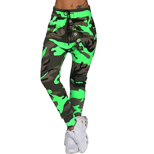 Pode incluir: Calças de camuflagem com um esquema de cores verde e marrom. As calças têm uma cintura com cordão e um fecho de botão.
