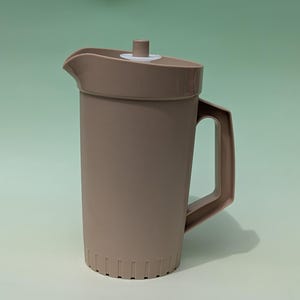 Può includere: Brocca in plastica color talpa con coperchio e manico abbinati. La brocca ha un beccuccio per versare facilmente e una superficie strutturata. Il coperchio ha una piccola maniglia cilindrica. Progettata per servire bevande, capacità di circa 2 litri.