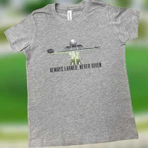 May include: A heather gray t-shirt with a silhouette of a football player and the text "ALWAYS EARNED. NEVER GIVEN."