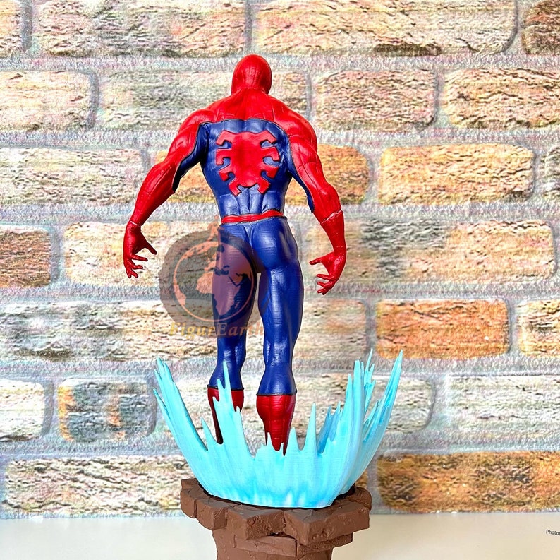 May include: A red and blue action figure of Spider-Man standing on a blue and white water effect base. The figure is posed with its back to the viewer, arms outstretched.