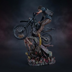 May include: A detailed figurine depicting a person riding a black motorcycle over a pile of decaying figures. The rider wears a dark vest and brown pants. The base features textured, blood-stained ground with multiple figures in various states of decay.