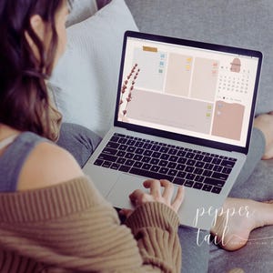May include: A person using a laptop computer with a digital planner open on the screen. The planner has a calendar, to-do list, and notes sections. The screen also features a floral design with lavender flowers.