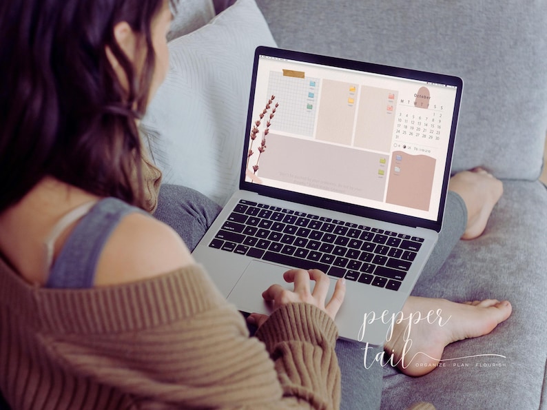 May include: A person using a laptop computer with a digital planner open on the screen. The planner has a calendar, to-do list, and notes sections. The screen also features a floral design with lavender flowers.