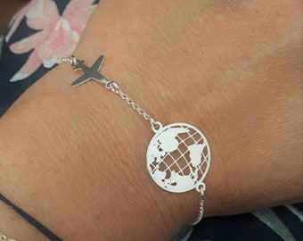 May include: Silver bracelet with a globe charm, a plane charm, and two dove charms with the names "Piotr" and "Kacper" engraved on them.