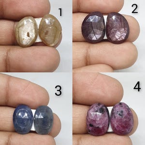 Puede incluir: Cuatro pares de piedras preciosas de forma ovalada en varios colores. El primer par es marrón claro, el segundo rojo oscuro, el tercero azul y el cuarto rosa y rojo. Cada par está unido por un adhesivo blanco.