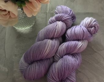 May include: Two skeins of lavender yarn with white streaks. The yarn is soft and fluffy, perfect for knitting or crocheting.