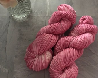 May include: Two skeins of pink yarn with a white ombre effect. The yarn is soft and fluffy, perfect for knitting or crocheting.