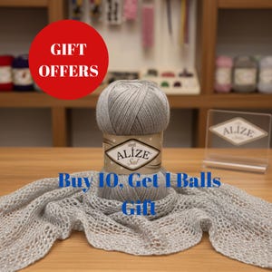 Può includere: Un gomitolo di filato Alize Sal grigio con un'etichetta decorativa, esposto con una sciarpa lavorata a maglia abbinata. L'immagine include un cerchio rosso con le parole "GIFT OFFERS" e il testo "Buy 10, Get 1 Balls Gift".