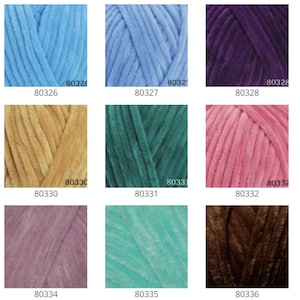 May include: A collection of 12 yarn skeins in various colors, including light blue, purple, gold, green, pink, brown, and gray. Each skein is labeled with a number.