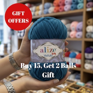 Op de afbeelding: Een tealblauwe bol Alize Velluto garen wordt vastgehouden voor een plank met kleurrijk garen. De tekst "GIFT OFFERS" staat in een rode cirkel. De tekst "Buy 15, Get 2 Balls GIFT" staat eronder.