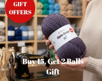 May include: A skein of purple yarn labeled "Alpine Alpaca" is held in front of a shelf of yarn. The text "Gift Offers" is in a red circle. The text "Buy 15, Get 2 Balls Gift" is below.
