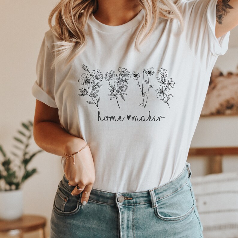 May include: White t-shirt with a black floral design and the text "home &hearts; maker".