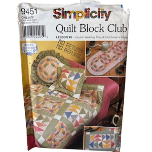Pode incluir: Padrão Simplicity Quilt Block Club para a Lição #6, Double Wedding Ring & Dutchman's Puzzle. O padrão inclui um edredom, uma almofada e um caminho de mesa com designs geométricos coloridos. A embalagem está rotulada como "Tamanho único".