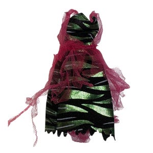 Peut inclure: Une robe de poupée à rayures vertes et noires, avec des lignes blanches. Elle est surmontée d'un tissu rose foncé, déchiré et transparent, créant un effet superposé. Les bords de la robe sont dentelés.