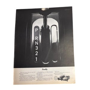 Puede incluir: Un anuncio vintage en blanco y negro para un coche Volkswagen. El anuncio presenta un primer plano de una palanca de cambios con las letras "P", "R", "N", "3", "2" y "1" visibles. El texto "Finalmente" está en la parte inferior del anuncio, junto con el lema "Solo pon la palanca en 3. (Sin que nadie te llame "DRIVE". Y conduce. Como lo harías con cualquier coche normal. Excepto que las gasolineras son más frecuentes. Despídete de tu viaje de 140 millas. Y saluda a conducir 140 millas con alguien. Porque necesitarás gasolina con menos frecuencia. Un galón te lleva 10 millas. O 15. O 25. Pero 25 millas. Entonces, ¿cómo haces lo que siempre hiciste en un Volkswagen? Automáticamente. Ahorra dinero."